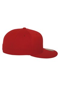 Punane pesapalli kübar lamedate äärega, valmistatud siledast tekstiilmaterjalist. Omab kuut paneeli ja väikest ülemist nuppu. Ilma logode või mustriteta.