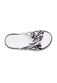 Black and white flip-flop sandal with a cow print design, featuring two wide straps, a textured white footbed, and a black sole.