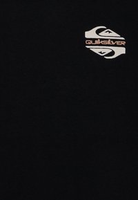 Svart t-shirt i bomull, med en vit och orange Quiksilver-logotyp på övre vänstra sidan. Mjuk textur, korta ärmar.