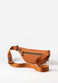 Borsa a tracolla arancione realizzata in materiale liscio, con una tasca frontale con zip, tracolla regolabile e dettagli in metallo.