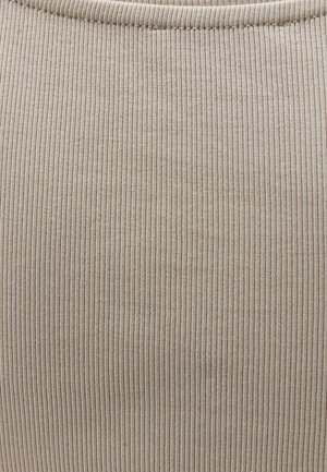 Primer plano de tela beige acanalada con textura de punto vertical y un borde ligeramente redondeado en la parte superior.