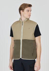 Khaki och olivgrön ärmlös väst med en mjuk fleece-nedre del, dragkedja och två sidofickor. Kontrastkanter.