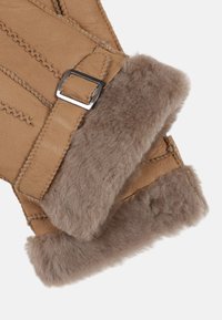 Tan leather gloves with a soft, gray fur lining and silver buckle detail; features visible stitching and a smooth texture.