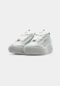 White FILA sneakers featuring a smooth, glossy upper, textured fabric laces, and a cushioned outsole with a patterned tread.