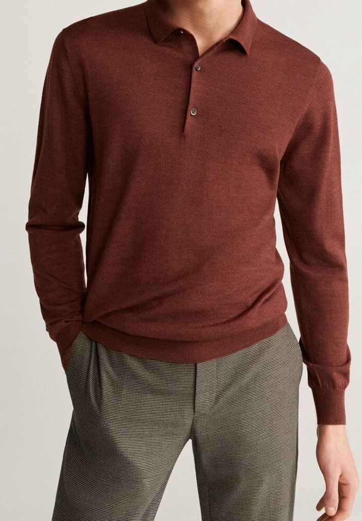 Burgundy pitkähihaista polo-paitaa, jossa on kolmipainikehihna, pehmeä tekstuuri ja ribbaus hihansuissa, yhdistettynä harmaisiin ruudullisiin housuihin.
