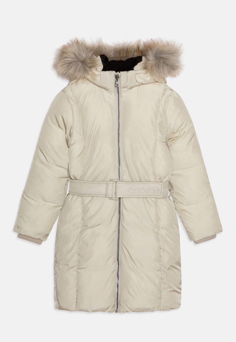 Bēšas pūkainas virsjakas ar kažokādas apdari uz kapuces, ar rāvējslēdzēju priekšā, jostu viduklī un logo detaļu. Iespējas ar garām piedurknēm un izšūta tekstūra.