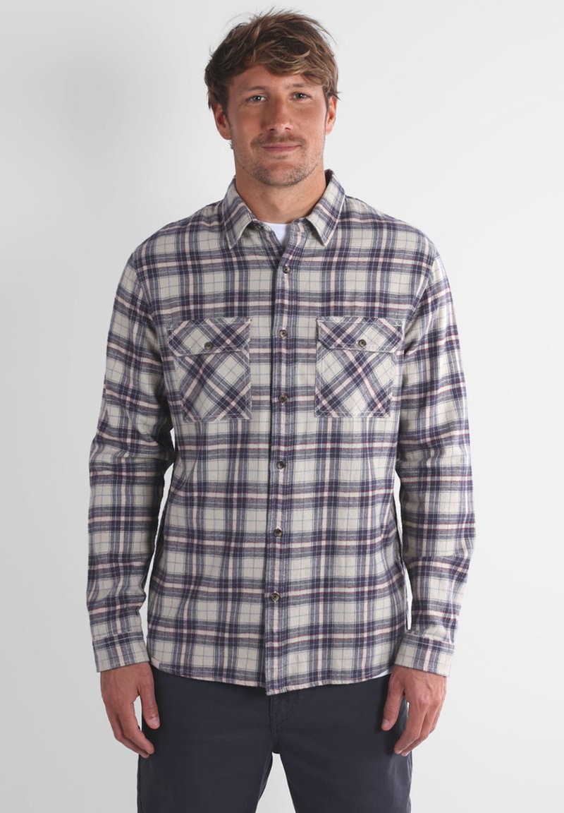 Chemise à manches longues à carreaux dans des tons crème, marine et bordeaux. Comprend deux poches poitrine, une coupe décontractée et une texture douce.