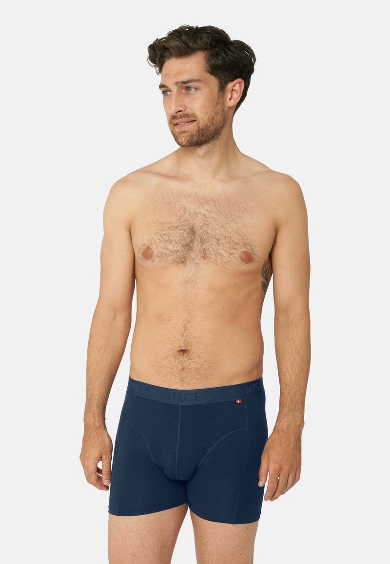 Boxers en coton bleu marine avec une taille élastique, présentant un détail de logo. Le tissu a l'air lisse avec un ajustement serré.