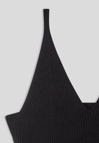 Bralette nero in maglia a costine con scollatura profonda a V e spalline sottili. La texture è liscia con righe verticali, caratterizzata da un design aderente.