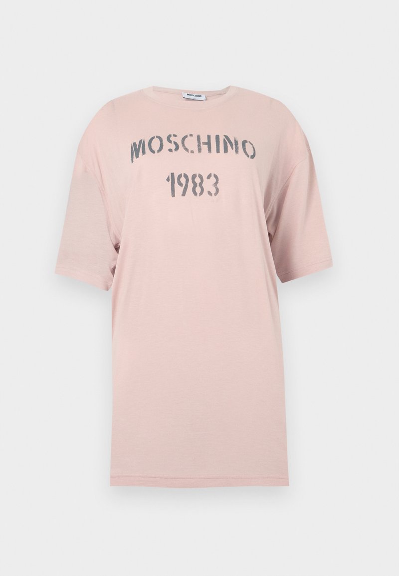 Light pink oversized T-shirt with short sleeves and "MOSCHINO 1983" printed in distressed gray text on the chest.