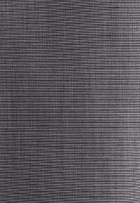 Tessuto strutturato grigio con motivo a griglia di piccoli puntini bianchi. Materiale morbido e leggero con una finitura superficiale liscia.