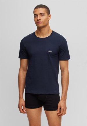 T-shirt bleu marine à manches courtes en tissu doux, avec un col rond et un petit logo "BOSS" blanc sur la poitrine gauche.