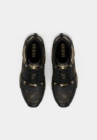 Czarne i złote sneakersy z wzorzystą cholewką, wykonane w eleganckim stylu, z grubymi sznurowadłami i kontrastową gumową podeszwą.