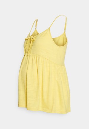 Haut de maternité jaune sans manches avec bretelles réglables et détail noué à l'avant sur un tissu doux texturé.