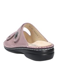 Pink leather slide sandal with a rounded toe, circular metallic accents, and a textured insole, featuring a soft black base and white stitching.