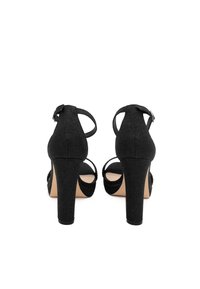 Sandali neri con tacco alto realizzati in tessuto testurizzato, con cinturini alla caviglia e un tacco ampio. Design open toe con suola liscia.