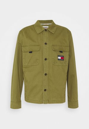 Chaqueta verde abotonada con dos bolsillos en el pecho, uno de ellos con un parche con el logo de Tommy Jeans.