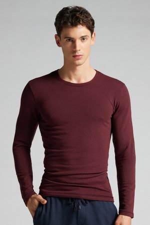 Bordeauxfarbene, langärmlige, enganliegende T-Shirt aus weicher Baumwolle, mit rundem Halsausschnitt und glatter Textur, kombiniert mit navyfarbenen Jogginghosen.