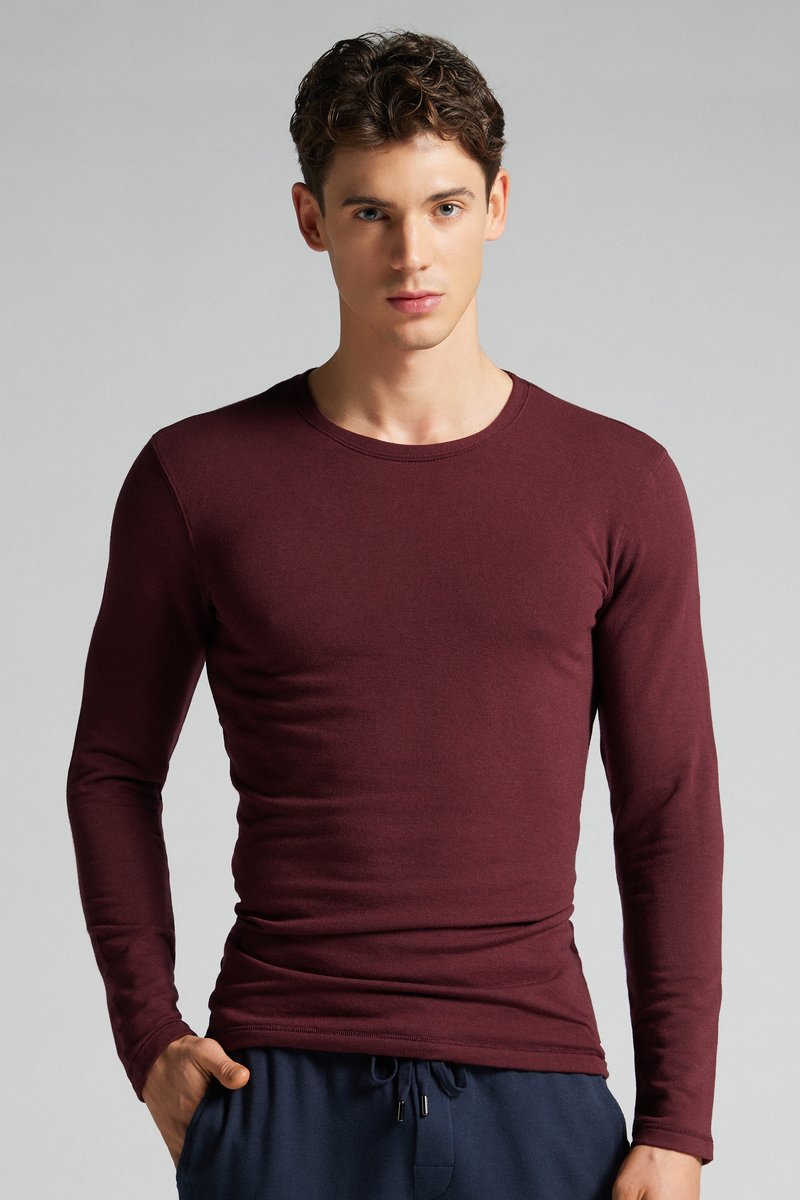 Bordeauxfarbene, langärmlige, enganliegende T-Shirt aus weicher Baumwolle, mit rundem Halsausschnitt und glatter Textur, kombiniert mit navyfarbenen Jogginghosen.