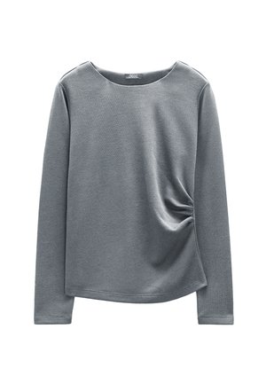 Szary, długi rękaw, wykonany z miękkiego materiału, z okrągłym dekoltem i marszczeniem po lewej stronie. Gładka faktura i luźny krój.