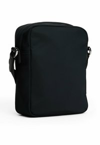 Bolsa mensajera negra de nailon con forma rectangular, textura suave, correa de hombro ajustable y diseño minimalista.