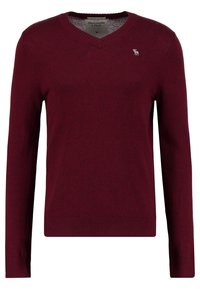 Burgundyvitt V-ringad tröja i mjukt tyg, med långa ärmar och ribbad nederkant. Broderad logotyp på bröstet.
