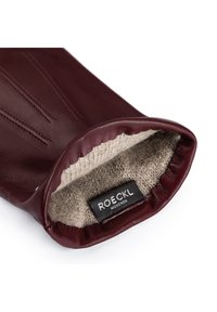 Bordeaux lederner Handschuh mit glatter Außenseite, weicher beige Wollfütterung und dezentem Nähen. Mit einem Etikett "ROECKL MÜNCHEN".