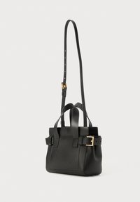 Borsa a mano in pelle nera con manici corti e una lunga tracolla regolabile. Caratterizzata da accessori dorati e una forma strutturata con fibbie laterali.