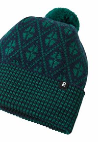 Dziana czapka w kolorze ciemnoniebieskim i zielonym, z geometrycznym wzorem, teksturowanym prążkowanym paskiem oraz puszystym pomponem na górze.