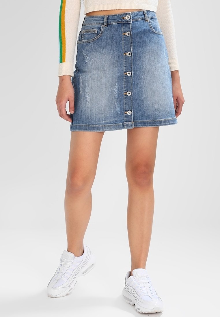 Jean kjol med en åtsittande silhuett, ljusblå tvätt, knäppning framtill och slitna detaljer. I kombination med vita sneakers.