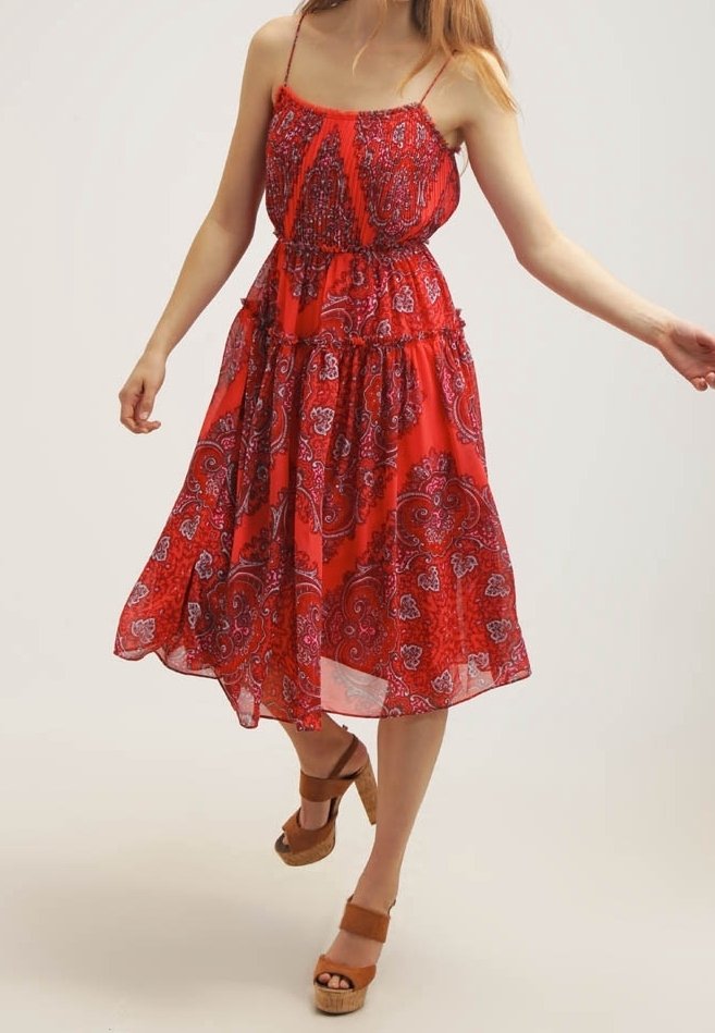Rotes, ärmelloses Kleid mit Paisleymuster, gerafftem Bund und fließendem Rock. Getragen mit braunen Plateau-Sandalen. Halbtransparentes Material.