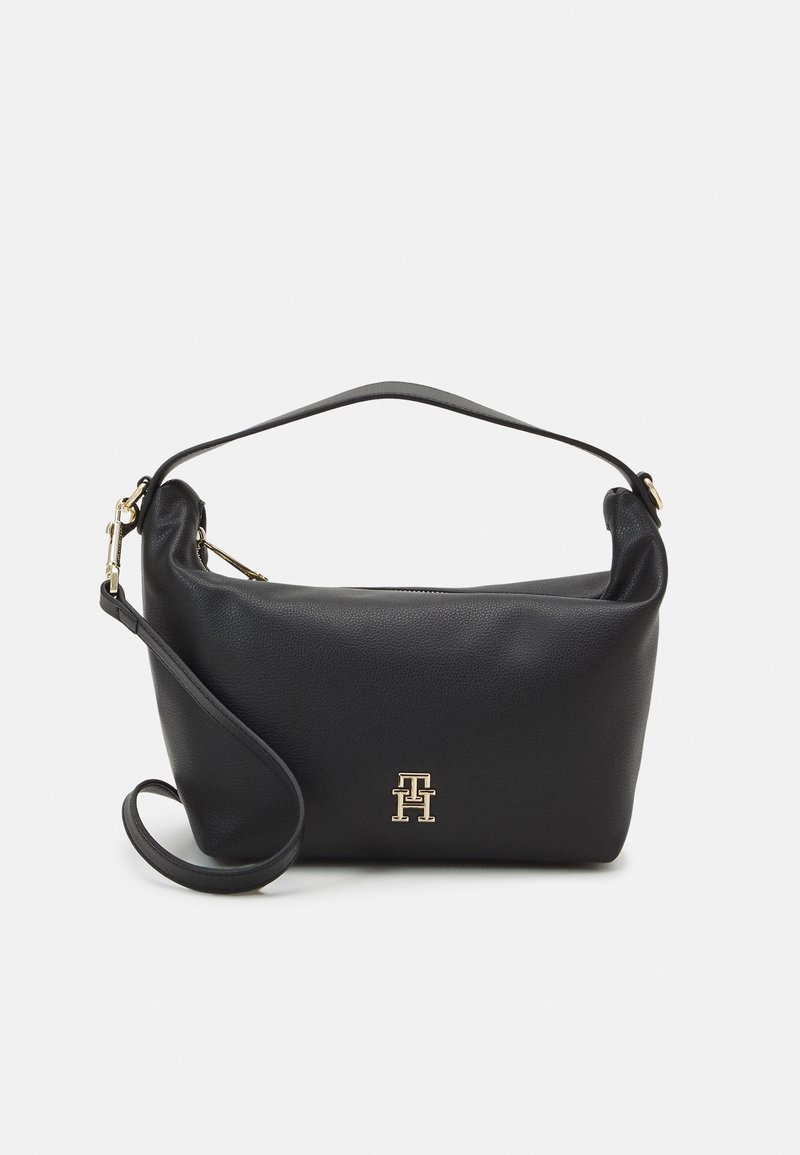 Sac bandoulière en cuir noir avec une anse courte et une longue sangle amovible, arborant un logo métal doré "TH" sur le devant.