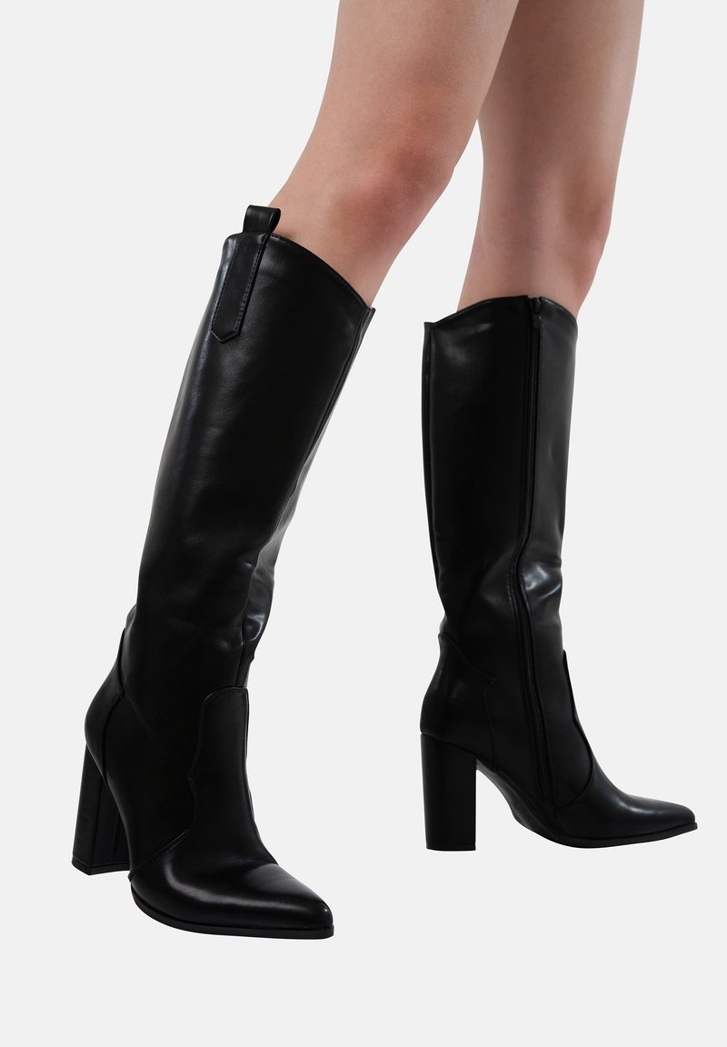 Botas negras de piel lisa hasta la rodilla, con puntera afilada, tacón grueso y cierre de cremallera en la parte posterior.