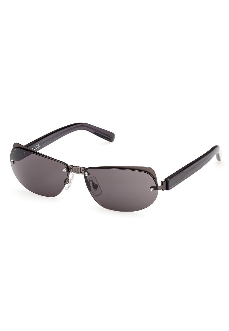 Gafas de sol con forma de ojo de gato, lentes oscuros, montura de plástico negro y detalle de bisagra metálica con logo grabado en la parte frontal.