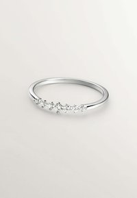 Anillo de plata con cinco pequeñas piedras redondas y transparentes engastadas en fila a lo largo de la parte superior. Superficie lisa y pulida con un diseño delicado.