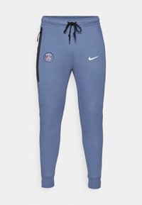 Blå sweatpants lavet af blødt stof, med et Paris-emblem på venstre lår og et hvidt Nike-logo på højre hofte. Elastiske manchetter.
