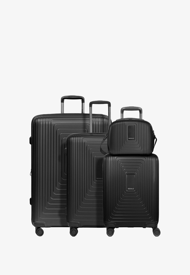 Tre valigie rigide nere di diverse dimensioni, con una texture rigata e superfici lisce, dotate di manici estensibili e ruote.