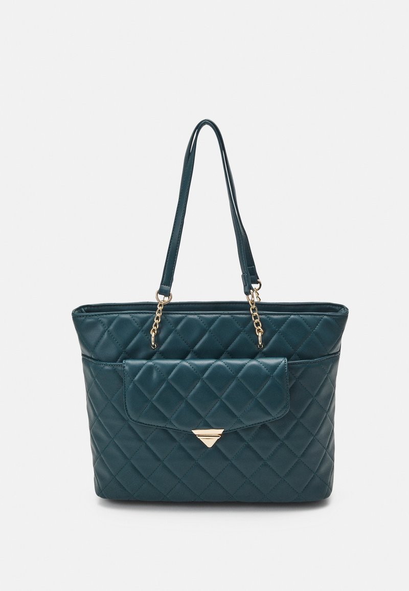 Teal quiltad tygväska med två kedjeprydda remmar, med en framficka med lucka och en guldtriangel detalj.