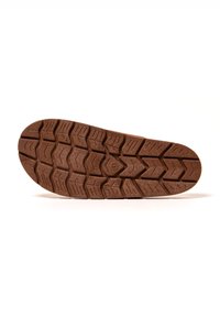 Gummisohle mit einer braunen texturierten Oberfläche, die ein Zickzackmuster und tiefe Rillen für Traktion aufweist. Zirkuläres Logo in der Mitte.