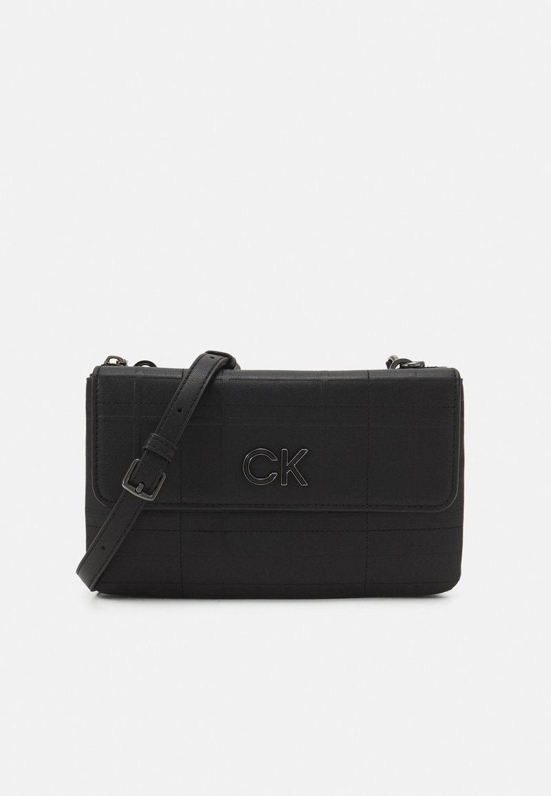 Czarna torebka na ramię wykonana z teksturowanego materiału, z klapką na zamek i wytłoczonym logo "CK" z przodu. W komplecie regulowany pasek.
