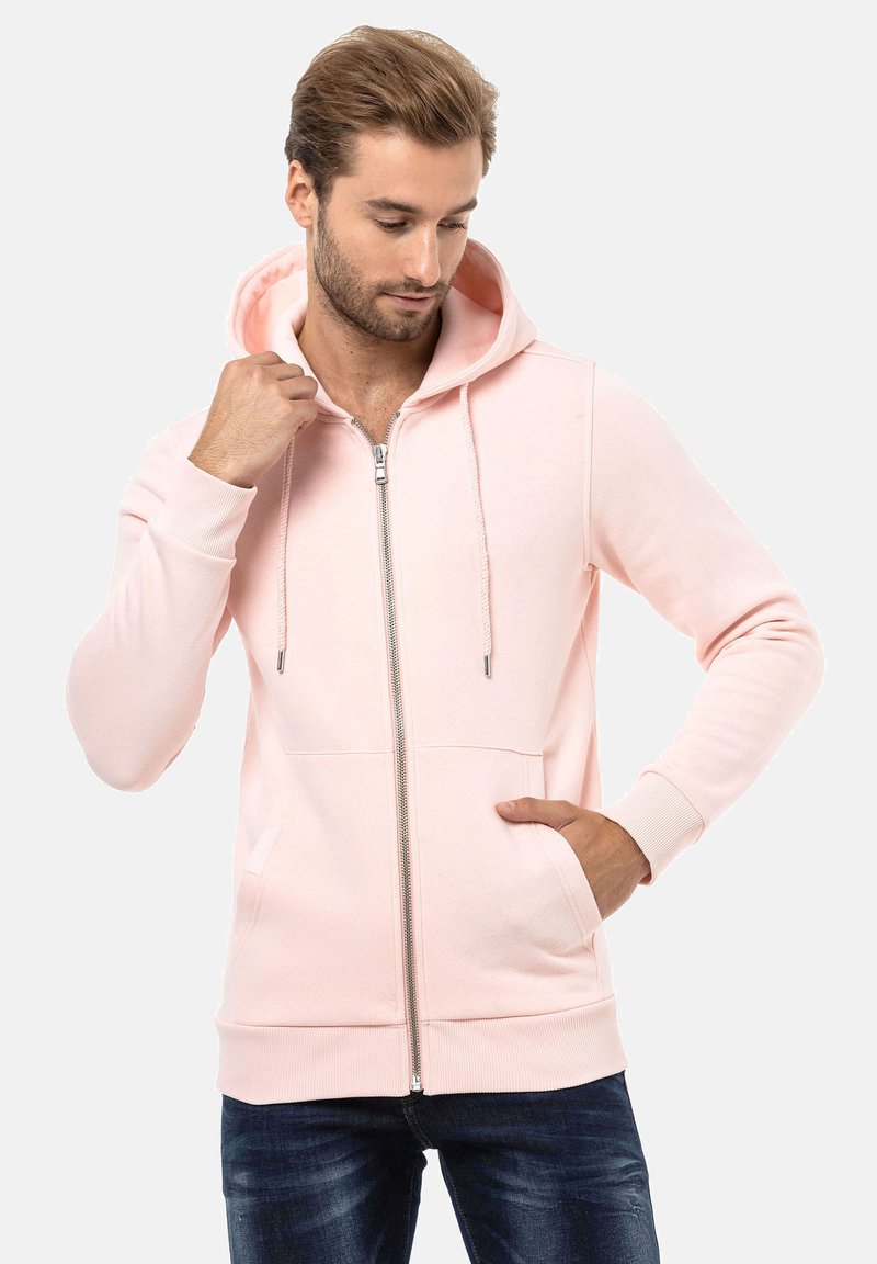 Lichtroze zip-up hoodie van zacht materiaal, met een capuchon, trekkoord, twee voorzakken en geribde mouwen.