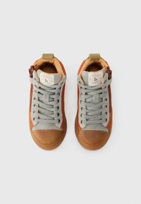 Høye sneakers med overdel i brun semsket skinn, grå stoffsider, gummitåhette, grå snørebånd og kontrasterende tan-nyanser. Logo detaljer synlig på tungen.