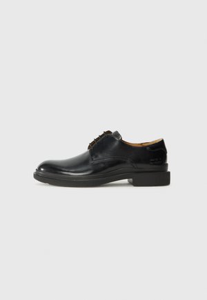 Scarpa da uomo in pelle nera con punta tonda, design con lacci, cuciture minime e suola in gomma robusta. Branding discreto sul tallone.