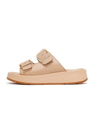 Sandalia de plataforma beige con dos tiras ajustables con textura y hebillas cuadradas en tono dorado, y suela de goma color tostado.