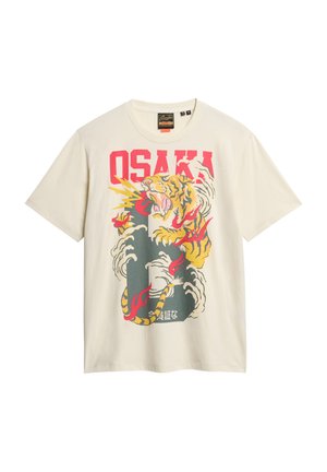 Cremefarvet t-shirt med et farverigt grafisk motiv af en tiger omgivet af skyer samt ordet "OSAKA" i fede røde bogstaver. Korte ærmer.
