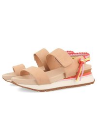 Sandalias beige con dos correas anchas, una plantilla acolchada y un acento trenzado multicolor en el talón. Suela de goma texturizada.