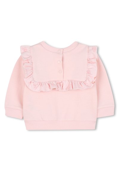 Sweatshirt rose avec un plastron à volants et des accents floraux, doté d'un col rond, de manches longues et d'une fermeture à boutons au dos.