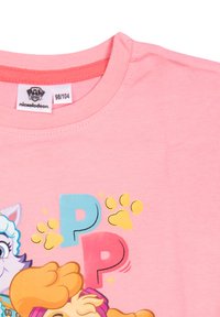 T-shirt di cotone rosa con personaggi dei cartoni animati e la lettera "P" in blu e rosso, con impronte gialle di zampe e un design vivace sul davanti.