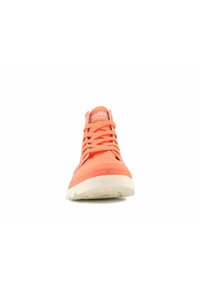 Pomarańczowy wysoki sneaker z materiałową cholewką, białą teksturowaną podeszwą i kontrastowym systemem sznurowania. Logo marki widoczne na języku.