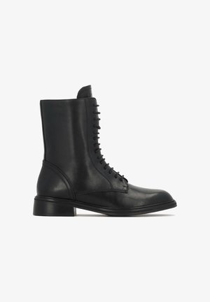 Schwarze Lederknöchelboots mit runder Zehenform, vertikalem Schnürdesign und niedrigem, gestapeltem Absatz. Glatte Textur mit minimalen Nähdetails.